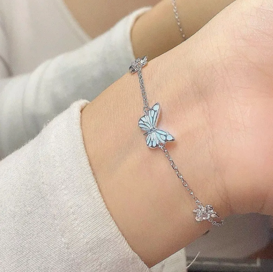 Sæt med halskæde og armbånd med lysende blå sommerfugl